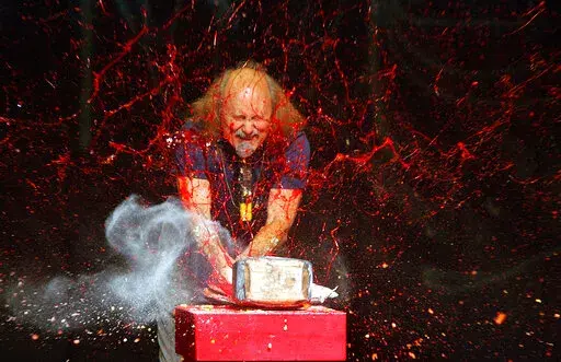 Comedian Gallagher smashes strawberry syrup and flour at the end of his performance at the Five Flags Theater in Dubuque, Iowa on In this Nov. 18, 2006. Gallagher, the smash-’em-up comedian who left a trail of laughter, anger and shattered watermelons over a decadeslong career, died Friday at his home in Palm Springs, Calif., after a brief illness. He was 76. (Jeremy Portje/Telegraph Herald via AP, File)