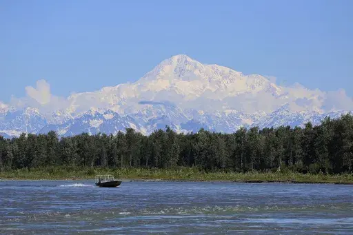 A boat is seen on the Susitna River near Talkeetna, Alaska, on Sunday, June 13, 2021, with Denali in the background. Denali, the tallest mountain on the North American continent, is located about 60 miles northwest of Talkeetna. (AP Photo/Mark Thiessen, File)