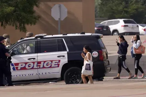 People raise their hands as they leave a shopping center after a shooting May 6, 2023, in Allen, Texas. Police released video footage Wednesday, June 28, of an officer killing a neo-Nazi gunman, quickly ending a mass shooting that left eight people dead and seven others wounded at the mall. The edited five-and-a-half-minute video details the final moments of Mauricio Garcia, 33, after he unleashed a rain of bullets from an AR-15-style rifle. (AP Photo/LM Otero, File)