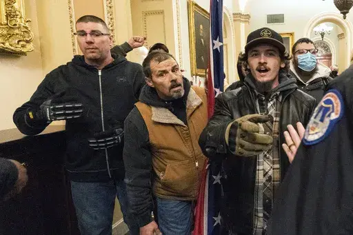 Michael Sparks, left, and Kevin Seefried, second from left, as they and other insurrectionists loyal to President Donald Trump are confronted by U.S. Capitol Police officers outside the Senate Chamber inside the Capitol in Washington, Jan. 6, 2021. Sparks, the first rioter to enter the Capitol building during the Jan. 6, 2021, attack has been convicted of charges that he interfered with police and obstructed Congress from certifying President Joe Biden's 2020 electoral victory.(AP Photo/Manuel B
