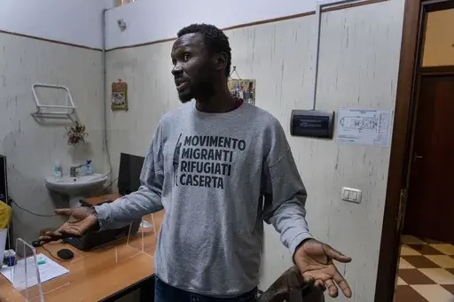 Mamadou Kouassi, left, a migrant who made the journey from his native Ivory Coast to Italy in 2006, talks to The Associated Press during an interview in a migrant center in Castel Volturno, southern Italy, where he now dedicates his life to working with migrants, Thursday, Feb. 1, 2024. Kouassi's odyssey through Africa inspired the movie Io Capitano (Me Captain) to Italian director Matteo Garrone and is among the nominees for the 2024 96th Academy Awards in the International Feature Film categor