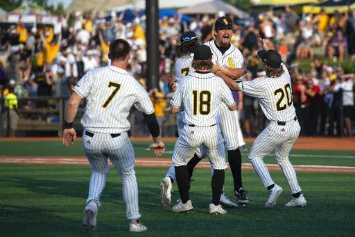 Southern Miss pitcher Tyler Stuart is embraced by his teammates as Southern Miss defeated LSU after an NCAA college baseball tournament regional game, Monday, June 6, 2022 in Hattiesburg, Miss. (Hannah Ruhoff/The Sun Herald via AP)