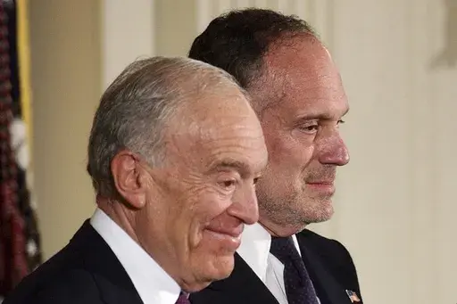 Leonard Lauder, left, and Ronald Lauder, sons of the late cosmetics mogul Estée Lauder, stand next to U.S. President George W. Bush, not pictured, as they receive the Presidential Medal of Freedom on her behalf, which was awarded posthumously to her during a ceremony at the White House in Washington, June 23, 2004. The sons of cosmetics giant Estée Lauder, along with her four grandchildren, pledged $200 million Tuesday, April 4, 2023, to the Alzheimer’s Drug Discovery Foundation, a nonprofit