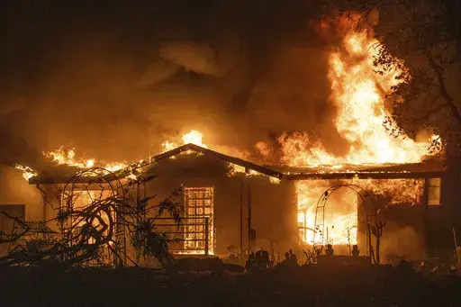 A house burns on Platina Road at the Zogg Fire near Ono, Calif., on Sept. 27, 2020. A Northern California judge on Wednesday, May 31, 2023, dismissed all charges against Pacific Gas & Electric for its role in the 2020 fatal wildfire sparked by its equipment that destroyed hundreds of homes and killed four people, including an 8-year-old child. (AP Photo/Ethan Swope, File)