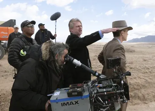 This image released by Universal Pictures shows director Christopher Nolan, center, and Cillian Murphy, right, on the set of "Oppenheimer." (Melinda Sue Gordon/Universal Pictures via AP)