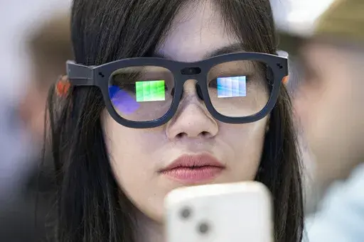 A visitor tests Ray Neo X2 Lite AR glasses during the Mobile World Congress 2024 in Barcelona, Spain, Monday, Feb. 26, 2024. The Mobile World Congress kicked off Monday in Barcelona, Spain, with mobile phone makers showing off new devices and telecom industry executives perusing the latest networking gear and software. (AP Photo/Pau Venteo)
