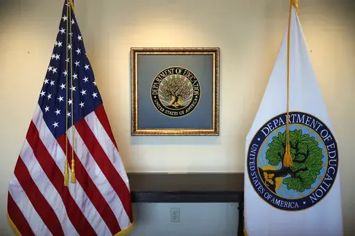 Flags decorate a space outside the office of the education secretary at the Education Department, Aug. 9, 2017, in Washington. College programs that leave graduates underpaid or buried in loans would be cut off from federal money under a proposal issued Wednesday, May 17, 2023, by the Biden administration, but the rules would apply only to for-profit colleges and a tiny fraction of programs at traditional universities. (AP Photo/Jacquelyn Martin, File)