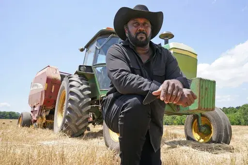 Farmer John Boyd Jr., poses for a portrait during a break from bailing hay at his farm in Boydton, Va., Thursday, May 27, 2021. (AP Photo/Steve Helber, File)