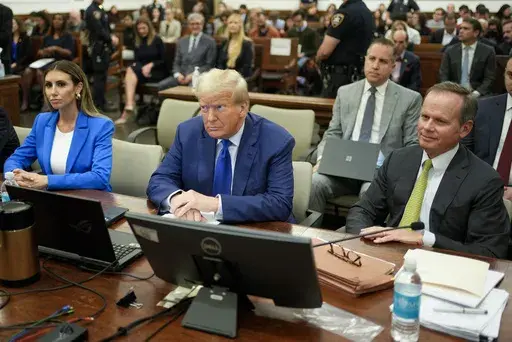 Former President Donald Trump, center, flanked by his defense attorneys, Alina Habba, left, and Chris Kiss, waits for the continuation of his civil business fraud trial at New York Supreme Court, Oct. 25, 2023, in New York. Trump's testimony on Monday will produce a rare spectacle of a former president being summoned to the stand as a trial witness. But Trump has actually had ample experience fielding questions from lawyers. His rhetorical style during years of depositions before becoming presid