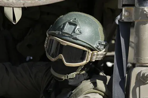 An Israeli soldier drives in a vehicle on the Israel-Gaza border, as seen from southern Israel, Friday, Oct. 18, 2024. (AP Photo/Tsafrir Abayov)