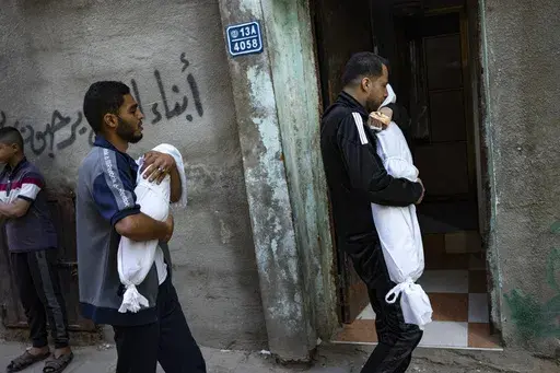 Members of the Abu Draz family hold the bodies of their relatives killed in the Israeli bombardment of the Gaza Strip, at their house in Rafah, southern Gaza, Thursday, April 4, 2024. (AP Photo/Fatima Shbair)