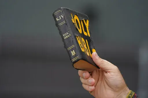 Bryan Peden, an anti-abortion supporter stands outside the Jackson Women's Health Organization clinic in Jackson, Miss., and waves his King James version of the Bible, as he cries out to women entering the medical facility to not have and abortion, Saturday, July 2, 2022. The clinic is the only facility that performs abortions in the state. (AP Photo/Rogelio V. Solis)