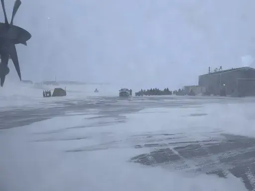 This March 28, 2023, photo shows townspeople in Gambell, Alaska, waiting in a snowstorm on four-wheelers to transport Alaska National Guard personnel from the air strip to the school for a ceremony. Sixteen Alaska National Guard members were honored for helping rescue the 11 crew members of a Navy plane that was shot down in 1955 by Soviet jet fighters and crash-landed about 8 miles from Gambell, on St. Lawrence Island, and 15 medals were presented posthumously. (AP Photo/Mark Thiessen)