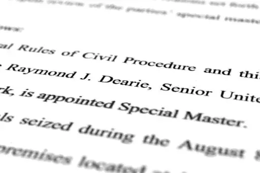 A page from the order by U.S. District Judge Aileen Cannon naming Raymond Dearie as special master to serve as an independent arbiter and to review records seized during the FBI search of former President Donald Trump's Mar-a-Lago estate, is photographed Thursday, Sept. 15, 2022. (AP Photo/Jon Elswick)