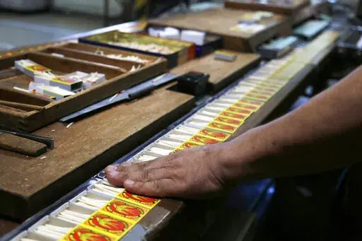 A worker makes sure matches are placed properly in the boxes of matches on an assembly line at a Nittosha factory in Himeji, Japan, Wednesday, June 29, 2022. Nittosha, a small Japanese manufacturer, is stopping the production of matchbooks. The company, which employs 130 people, is a testament to the hard work and dedication at small and medium-size companies that are the backbones of large economies, including the U.S. and Japan. (AP Photo/Yuri Kageyama)