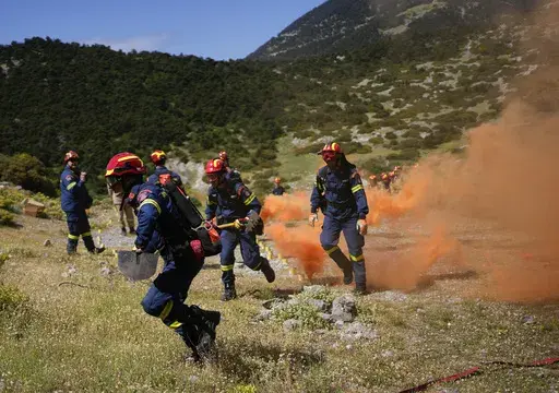 Firefighters of the 1st Wildfire Special Operation Unit, take part in a drill near Villia village some 60 kilometers (37 miles) northwest of Athens, Greece, Friday, April 19, 2024. Greece's fire season officially starts on May 1 but dozens of fires have already been put out over the past month after temperatures began hitting 30 degrees Celsius (86 degrees Fahrenheit) in late March. This year, Greece is doubling the number of firefighters in specialized units to some 1,300, adopting tactics from