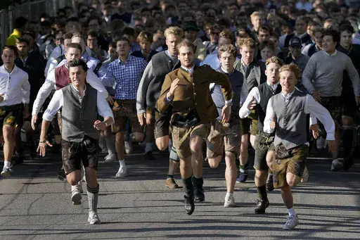 People run to enter the 188th 'Oktoberfest' beer festival in Munich, Germany, Saturday, Sept. 16, 2023. (AP Photo/Matthias Schrader)
