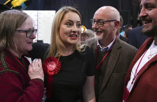 Labour Party candidate Gen Kitchen celebrates with her family after being declared winner in the Wellingborough by-election at the Kettering Leisure Village, Northamptonshire, Friday Feb. 16, 2024. (Joe Giddens/PA via AP)