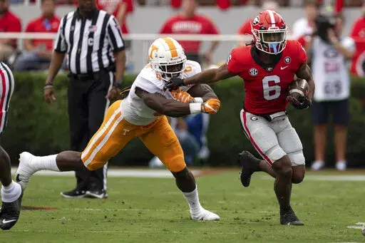 Georgia running back Kenny McIntosh, right, fends off Tennessee defensive lineman Byron Young during the first half of an NCAA college football game Saturday, Nov. 5, 2022 in Athens, Ga. (AP Photo/John Bazemore)