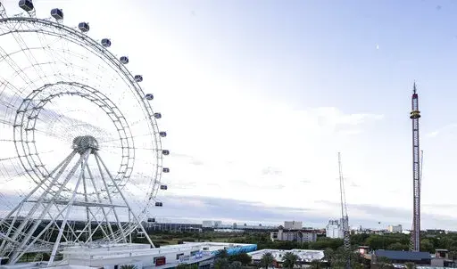 The Wheel and Orlando Free Fall ride at ICON Park is shown on Friday, March 25, 2022 in Orlando, Fla.  A 14-year-old boy fell to his death from a ride at an amusement park in Orlando, sheriff's officials said. Sheriff's officials and emergency crews responded to a call late Thursday at Icon Park, which is located in the city's tourist district along International Drive. The boy fell from the Orlando Free Fall ride, which opened late last year. (Willie J. Allen Jr. /Orlando Sentinel via AP)