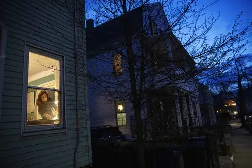 McKenna Shuster works on a linocut art print which she does as a hobby in her home on the last night of a two-week self-isolation while recovering from symptoms of COVID-19 in Somerville, Mass., on March 26, 2020. On Friday, March 1, 2024, the Centers for Disease Control and Prevention said people who test positive for COVID-19 no longer need to stay in isolation for five days. The CDC changed its longstanding guidance, saying that people can return to work or regular activities if their symptom
