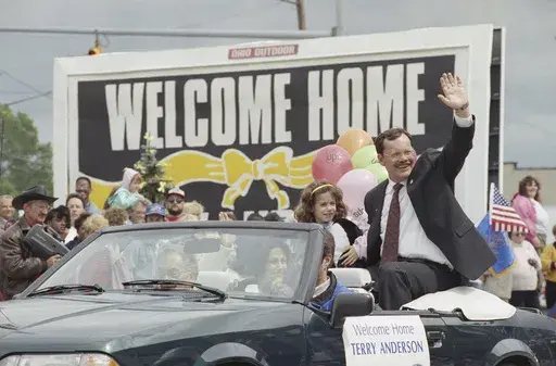 Former hostage Terry Anderson waves to the crowd as he rides in a parade in Lorain, Ohio, June 22, 1992. Anderson, the globe-trotting Associated Press correspondent who became one of America’s longest-held hostages after he was snatched from a street in war-torn Lebanon in 1985 and held for nearly seven years, died Sunday, April 21, 2024. He was 76. (AP Photo/Mark Duncan, File)