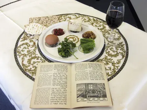 A 1936 Maxwell House Haggadah sits on a desk alongside a Seder plate on March 15, 2011, in New York. (AP Photo/Stace Maude, File)