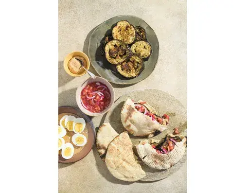 This image released by Milk Street shows a recipe for charred eggplant pita sandwiches with spicy tahini. (Milk Street via AP)