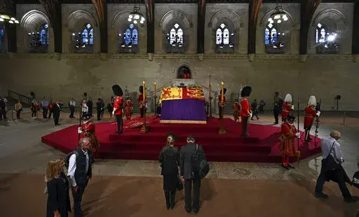 Members of the public file past the coffin of Queen Elizabeth II, inside Westminster Hall, at the Palace of Westminster, in London Wednesday, Sept. 14, 2022, where it Lies in State on a Catafalque. Queen Elizabeth II will lie in state in Westminster Hall inside the Palace of Westminster, from Wednesday until a few hours before her funeral on Monday, with huge queues expected to file past her coffin to pay their respects.  (Ben Stansall/Pool Photo via AP)