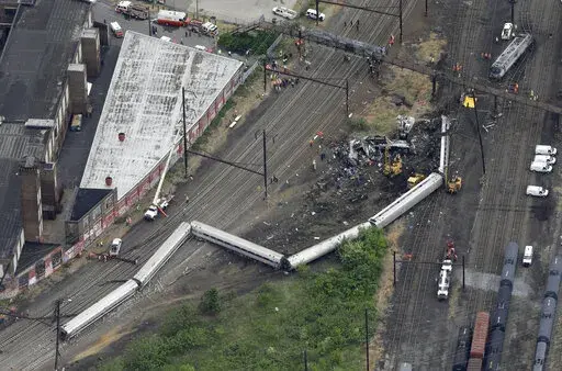 FILE- In this Wednesday, May 13, 2015, file photo, emergency personnel work at the scene of a derailment in Philadelphia of an Amtrak train headed to New York. A Philadelphia jury is expected weigh criminal charges Friday, March 4, 2022, against Amtrak engineer Brandon Bostian over the deadly derailment. (AP Photo/Patrick Semansky, File)