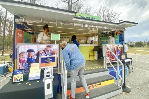 In this photo provided by the National Institute of Health's "All of Us" research program, people visit a study vehicle in Silver Spring, Md. on March 8, 2022. The study aims to eventually enroll a million Americans from all walks of life in a genomic database, part of a quest to reduce health disparities and offer care that's more tailored than today's one-size-fits-all approach. (Dianne Beltran/All of Us Research Program via AP)