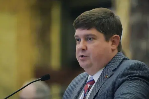 State Sen. Jeremy England, R-Vancleave, presents legislation in the Senate Chamber at the Mississippi Capitol in Jackson, Feb. 1, 2023. England says he intentionally wore an embarrassing Halloween costume to raise money for breast cancer research — a shiny pink bodysuit with a short pink skirt. Now, three years later, England says a photo of him in the outfit is being misused in an increasingly divisive GOP primary as he supports Lt. Gov. Delbert Hosemann for reelection. (AP Photo/Rogelio V. S