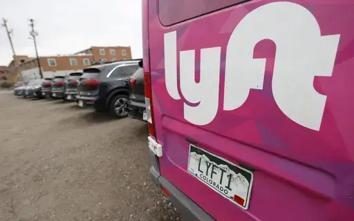 A Lyft ride-hailing vehicle is parked near Empower Field at Mile High in Denver on April 30, 2020. (AP Photo/David Zalubowski, File)