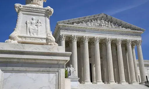 The U.S. Supreme Court is seen, with a carving of Justice in the foreground, April 19, 2023, in Washington. A Black Ohio woman who miscarried in her bathroom has been charged with abuse of a corpse and awaits grand jury action. Her case has sparked a national firestorm over the plight of pregnant women, especially women of color, following the U.S. Supreme Court’s decision to overturn Roe v. Wade. (AP Photo/Jacquelyn Martin, File)