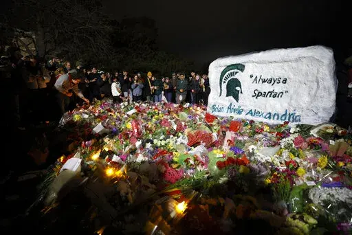 Mourners attend a vigil at The Rock on the grounds of Michigan State University in East Lansing, Mich., Wednesday, Feb. 15, 2023. Alexandria Verner, Brian Fraser and Arielle Anderson were killed and several other students remain in critical condition after a gunman opened fire on the campus of Michigan State University Monday night. (AP Photo/Al Goldis)