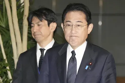 Japan's Prime Minister Fumio Kishida, right, meets reporters after an army helicopter went missing, at his official residence in Tokyo Thursday, April 6, 2023. Japan's coast guard says it is searching for an army helicopter carrying 10 crew members that went missing off a southern Japanese island. Kishida said the Defense Ministry is investigating and "We will do our utmost to save their lives." (Kyodo News via AP)