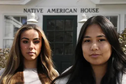 Dartmouth College students Marisa Joseph, right, a member of the Tulalip Tribes of Washington, poses with Ahnili Johnson-Jennings, left, a member of the Quapaw, Choctaw, Sac and Fox and Miami tribes, pose outside the Native American House at Dartmouth College, Friday, April 7, 2023, in Hanover, N.H. The college announced in March 2023 that it housed partial Native American skeletal remains in their collection. Dartmouth has set in motion an effort to repatriate the remains to the appropriate tri
