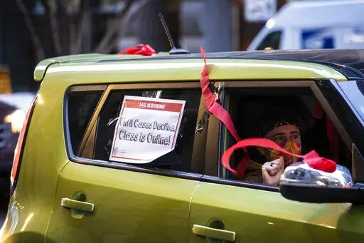 Members of the Chicago Teachers Union and supporters stage a car caravan protest outside City Hall in the Loop, Jan. 5, 2022. Talks between Chicago school leaders and the teachers union resumed Sunday, Jan. 9, 2022 amid a standoff over remote learning and other COVID-19 safety measures. The situation looms over the start of a second week of school after three days of canceled classes in the nation’s third-largest district. (Ashlee Rezin /Chicago Sun-Times via AP)
