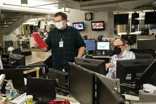 With the Florida results in his hand, Deputy Managing Editor David Scott, left, who helps oversee The Associated Press' coverage of elections, calls that race in favor of President Donald Trump on Election night at the Washington bureau of the AP, Wednesday, Nov. 4, 2020. (AP Photo/Pablo Martinez Monsivais, File)