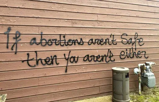 Threatening graffiti is seen on the exterior of Wisconsin Family Action offices in Madison, Wis., May 8, 2022. Investigators on Tuesday, March 28, 2023, finally captured the man they believe firebombed the prominent Wisconsin anti-abortion lobbying group's office last year ahead of the U.S. Supreme Court's decision to overturn its landmark Roe v. Wade ruling. The U.S. attorney's office in Madison announced that police arrested 29-year-old Hridindu Sankar Roychowdhury at Boston's Logan Internatio