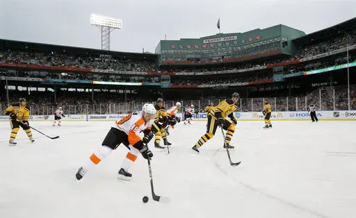 FILE — Philadelphia Flyers center Danny Briere (48) skates with the puck as Boston Bruins defenseman Zdeno Chara, right, defends in the second period of the New Year's Day Winter Classic NHL hockey game on an outdoor rink at Fenway Park in Boston, Jan. 1, 2010. Fenway Park has kept busy in the offseason with hockey, football and other events that have turned one of baseball's crown jewels into a year-round venue. (AP Photo/Elise Amendola, File)