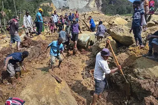 CORRECTS TO YAMBALI FOR LOCATION, NOT POGERA - Villagers search through a landslide in Yambali, in the Highlands of Papua New Guinea, Sunday, May 26, 2024. The International Organization for Migration feared Sunday the death toll from a massive landslide is much worse than what authorities initially estimated. (Mohamud Omer/International Organization for Migration via AP)