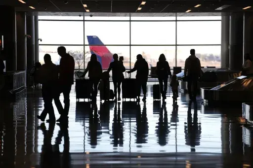People pass through Salt Lake City International Airport Wednesday, Jan. 11, 2023, in Salt Lake City. To catch up with your credit-savvy friends, you may be considering a credit card that earns cash-back or travel rewards. If you have one already, perhaps you want to add a second card to the mix to earn even more. (AP Photo/Rick Bowmer, File)