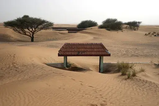 A house's entrance gate is buried under the sand at the Bedouin village of al-Ghuraifabout 100 km, 62 miles, southeast of Sharjah, United Arab Emirates, Sunday, July 9, 2023. Built-in the 1970s, the village was abandoned two decades later as oil wealth transformed the country into a global hub of commerce and tourism, home to the futuristic cities of Dubai and Abu Dhabi. (AP Photo/Kamran Jebreili)