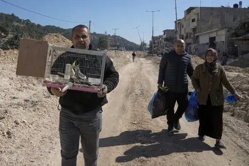 Residents of the West Bank urban refugee camp of Nur Shams evacuate their homes and carry their belongings as the Israeli military continues its operation in the area on Wednesday, Feb. 26, 2025. (AP Photo/Majdi Mohammed)