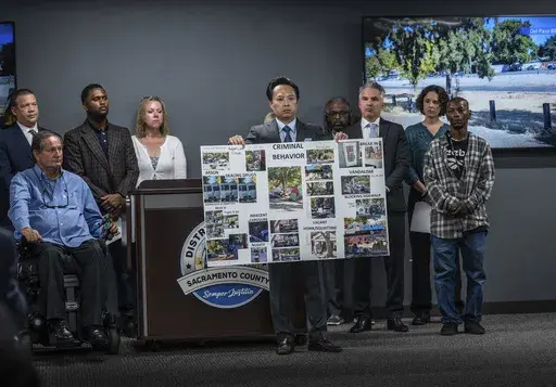 Sacramento County District Attorney Thien Ho holds a poster collage titled "criminal behavior" as he announces on Tuesday, Sept. 19, 2023, that his office is suing the city of Sacramento for creating a public nuisance by failing to take stronger action on homeless camps. A Sacramento prosecutor is suing California's capital city over failure to clean up homeless encampments. Sacramento District Attorney Thien Ho says his office asked the city to enforce laws around sidewalk obstruction and to cr