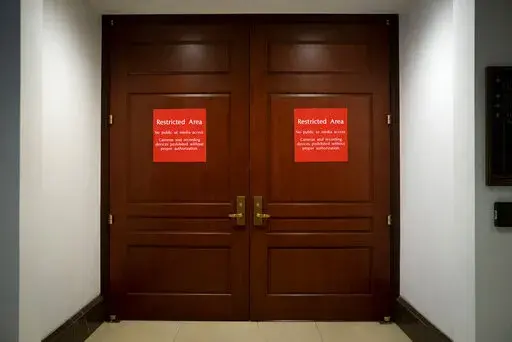 Bright red signs alert non-authorized personnel at the entrance to the House SCIF, the Sensitive Compartmented Information Facility, located three levels beneath the Capitol where witnesses and lawmakers hold closed interviews in the impeachment inquiry on President Donald Trump's efforts to press Ukraine to investigate his political rivals, in Washington, Nov. 6, 2019. When members of Congress want to peruse classified materials, they descend deep into the basement of the Capitol to a sensitive