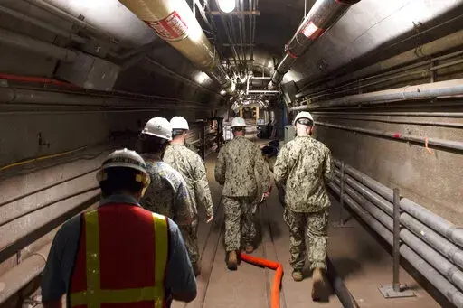 In this Dec. 23, 2021, photo provided by the U.S. Navy, Rear Adm. John Korka, Commander, Naval Facilities Engineering Systems Command (NAVFAC), and Chief of Civil Engineers, leads Navy and civilian water quality recovery experts through the tunnels of the Red Hill Bulk Fuel Storage Facility, near Pearl Harbor, Hawaii. The U.S. government on Friday, April 22, 2022 dropped its appeals of a Hawaii order requiring it to remove fuel from a massive military fuel storage facility that leaked petroleum 