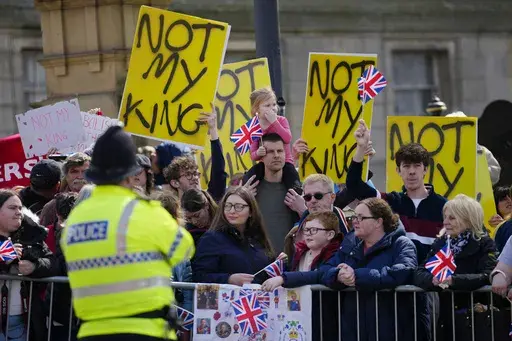 Protestors wait for the arrival of King Charles III and Camilla, the Queen Consort to visit Liverpool Central Library, and to officially mark the Library's twinning with Ukraine's first public Library, the Regional Scientific Library in Odesa, in Liverpool, England, Wednesday, April 26, 2023. There will be dissenters among the cheering crowds when King Charles III travels by gilded coach to his coronation. More than 1,500 protesters will be dressed in yellow for maximum visibility and they plan 