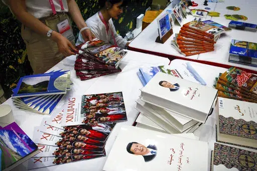 Copies of the book on the governance of Chinese President Xi Jinping are displayed with booklets promoting Xinjiang during a news conference by Shohrat Zakir, chairman of China's Xinjiang Uighur Autonomous Region, at the State Council Information Office in Beijing on July 30, 2019. As the Chinese government tightened its grip over its ethnic Uyghur population, it sentenced one man to death and three others to life in prison in 2021 for textbooks drawn in part from historical resistance movements